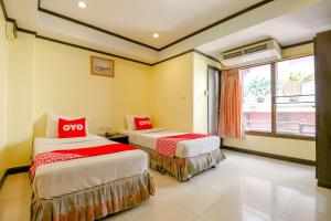 due letti in una stanza con una finestra di Hotel Win Long a Bangkok