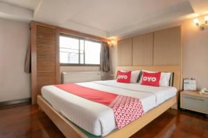 una camera da letto con un grande letto con cuscini rossi di Hotel Win Long a Bangkok