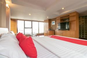 una camera da letto con un grande letto con cuscini rossi di Hotel Win Long a Bangkok