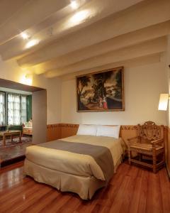 a bedroom with a bed and a painting on the wall at Tambo del Arriero Hotel Boutique in Cusco