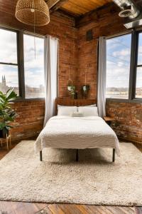 a bedroom with a bed in a brick wall at 420 Friendly Canada Bridge View Loft Downtown FREE parking in Detroit