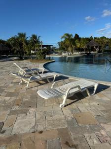 Una fila de sillas de salón junto a un cuerpo de agua. en RM Beach Paradise - Barra Iloa Residense, en Barra de São Miguel 47 fotos más