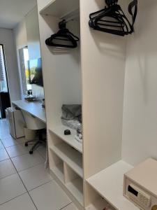 Una habitación con estantes blancos y un escritorio con una computadora. en RM Beach Paradise - Barra Iloa Residense, en Barra de São Miguel