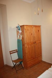 um quarto com uma cadeira e um armário de madeira em Governor's Inn Apartments em Gibraltar