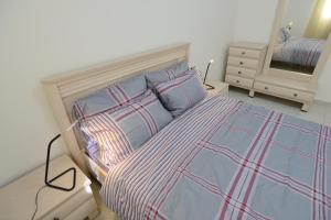 a bedroom with a bed and a dresser with a mirror at Olga Beach Apartments in Haifa