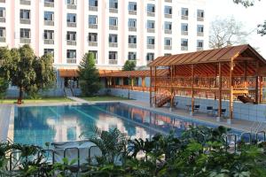 a swimming pool with a gazebo in front of a building at Sogecoa Golden Peacock in Lilongwe