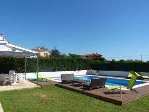 un patio trasero con una piscina con sillas y una mesa en Belvilla by OYO Bon Relax II45 en Sant Pere Pescador