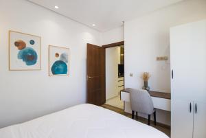 a bedroom with a white bed and a desk at Luxury Marina Retreat, Walk to the Beach in Tangier