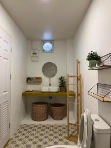 a bathroom with a toilet and a shelf with a mirror at The Summer Cottage in Khlaung Phai Bae +36 photos