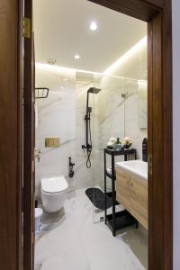 a bathroom with a toilet and a sink and a shower at Luxury Marina Retreat, Walk to the Beach in Tangier