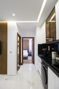 a kitchen with white walls and black counter tops at Luxury Marina Retreat, Walk to the Beach in Tangier +12 photos