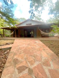 a house with a stone walkway in front of it at Casa Rosier - Charme rústico e aconchegante em Lençóis in Lençóis