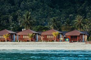 a row of houses on a beach next to the water at PingChan Koh Phangan Beachfront Resort in Thong Nai Pan Yai