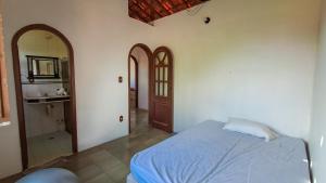 ベラ・クルス・デ・イタパリカにあるCasa de Praia na Ilha - Barra do Poteのベッドルーム1室(ベッド1台付)、バスルーム(鏡付)