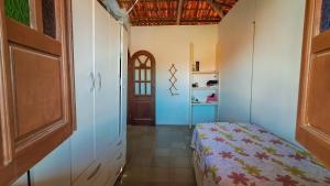 ベラ・クルス・デ・イタパリカにあるCasa de Praia na Ilha - Barra do Poteの小さなベッドルーム(ベッド1台、ドア付)