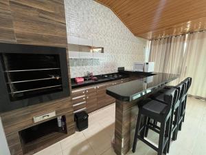 a kitchen with a bar with stools and a stove at Casa espaço inteiro em Santarém é aqui in Santarém