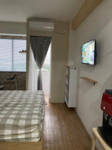 a bedroom with a bed and a window and a television at Hotel Mawar Indah in Bandung