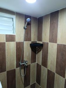 a shower in a room with wooden walls at Apart hotel Costa Verde#7 con cama Queen in Las Galeras