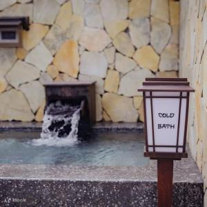 einen Brunnen mit einem Licht vor einer Steinmauer in der Unterkunft Wyndham Lynn Times Thanh Thủy in La Phu