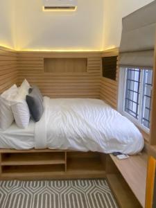 a bedroom with a bed with white sheets and pillows at Petite Stylish 1Bed Apt Courtyard Lekki1 in Lekki Phase 1
