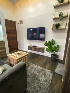 a living room with a couch and a tv on a wall at Petite Stylish 1Bed Apt Courtyard Lekki1 in Lekki Phase 1