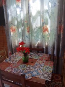 a table with a vase of flowers on top of it at Alojamiento nayla y yaya in Puerto Iguazú