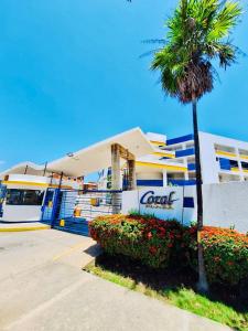 ein Gebäude mit einer Palme davor in der Unterkunft Coral Plaza Lechería Vacaciones cerca de playa in El Morto de Barcelona