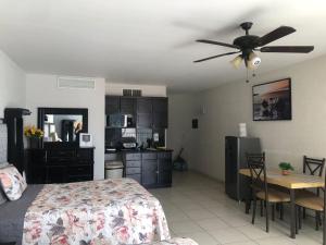a bedroom with a bed and a kitchen with a ceiling fan at Condominio Yaqui 320 in San Carlos
