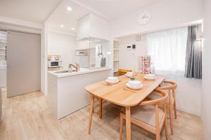 Una cocina y un comedor con mesa y sillas de madera. en self-check in misimaya building, en Tokio