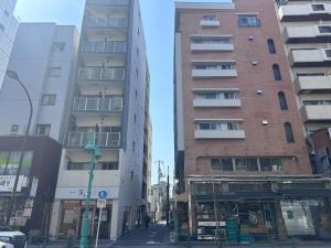 Un edificio alto en una calle de la ciudad con edificios. en self-check in misimaya building, en Tokio
