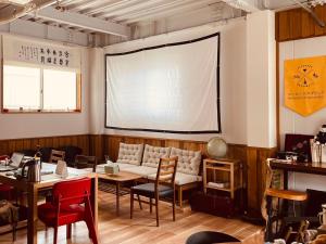 a meeting room with a couch and a large screen at CCCOFFEE HOSTEL Kobe in Kobe