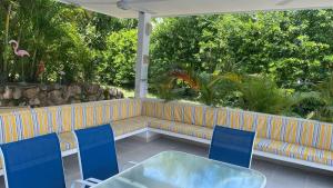 Un patio con un sofá y sillas y una mesa. en HERMOSA VILLA FAMILIAR CONDOMINIO CAMPESTRE EL PEÑON Piscina Privada Campo de Golf, en Girardot