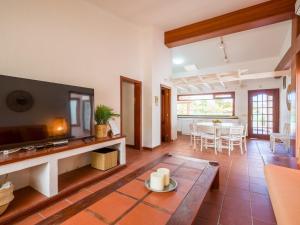 una sala de estar con un televisor y una mesa en Chalet in Maspalomas with Heated Pool, en San Bartolomé