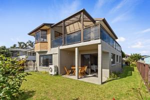 Casa con ventanas grandes y césped en Sandbanks - Papamoa Beachfront Holiday Home, en Papamoa