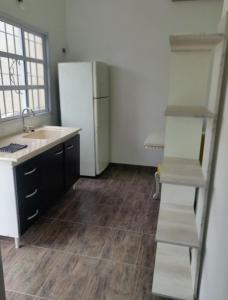 a kitchen with a sink and a refrigerator at hospedaje monte grande in Monte Grande
