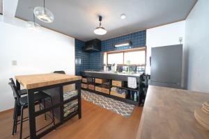 a kitchen with a table and a refrigerator at Shiraoi Villa ATUY ファミリーオススメ 長期滞在OK 閑静な住宅 in Shiraoi