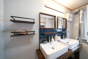 a bathroom with two sinks and a mirror at Shiraoi Villa ATUY ファミリーオススメ 長期滞在OK 閑静な住宅 in Shiraoi +56 photos