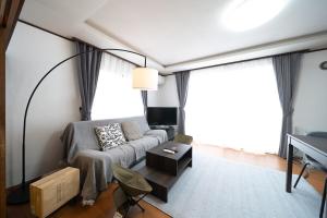 a living room with a couch and a table at Shiraoi Villa ATUY ファミリーオススメ 長期滞在OK 閑静な住宅 in Shiraoi