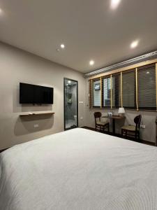 a bedroom with a large bed with a flat screen tv at Studio 3 ByhomeLinh Phố Cổ Hoàn Kiếm in Hanoi