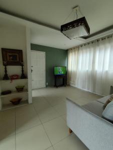a living room with a couch and a television at Rota das Praias in Vila Velha