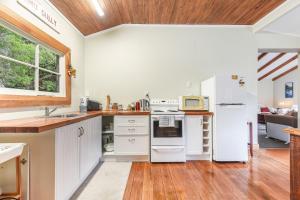 哈夫洛克Fantail Cottage Kaiuma Bay - Havelock Holiday Home的一间厨房,配有白色家电和木制天花板