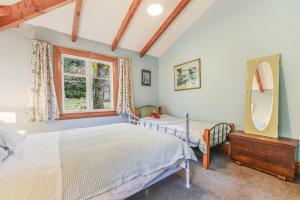 哈夫洛克Fantail Cottage Kaiuma Bay - Havelock Holiday Home的一间卧室，里面有一张床和一扇窗户。