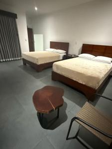Habitación con 2 camas y taburete. en Scala Inn, en Muelle 7 fotos más