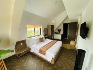 a bedroom with a large bed and a window at Nắng's Villa & Coffee in Ấp Ða Lợi
