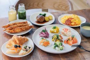 four plates of food on a wooden table at Via Inn Prime Osaka Kyobashi in Osaka