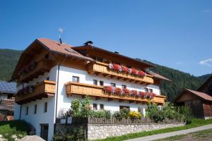 ein Gebäude mit Blumenkästen an der Seite in der Unterkunft Hölzlhof Apartments in Oberrasen