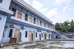 a building with a balcony on top of it at OYO Life 90433 Serasi Kost in Palembang