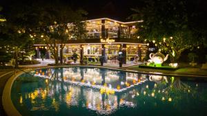a large pool with lights in front of a building at Tea Resort in Bảo Lộc