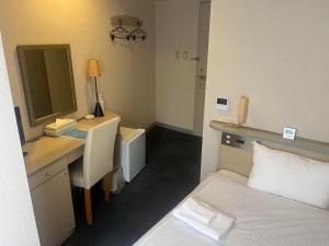 四万十市Hotel Kokomo的卧室里有一张床、一张书桌和一面镜子