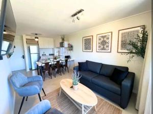 a living room with a blue couch and a table at Departamento en Algarrobo in Algarrobo